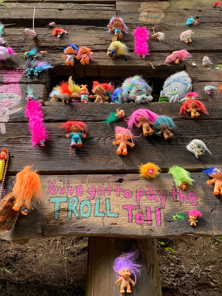 troll toy art display on wood bridge