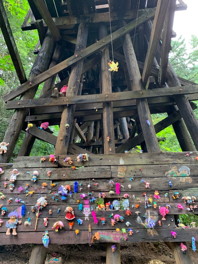 Troll toys nailed to wooden bridge