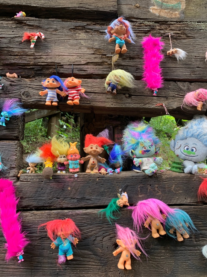 Troll toys nailed to wooden bridge
