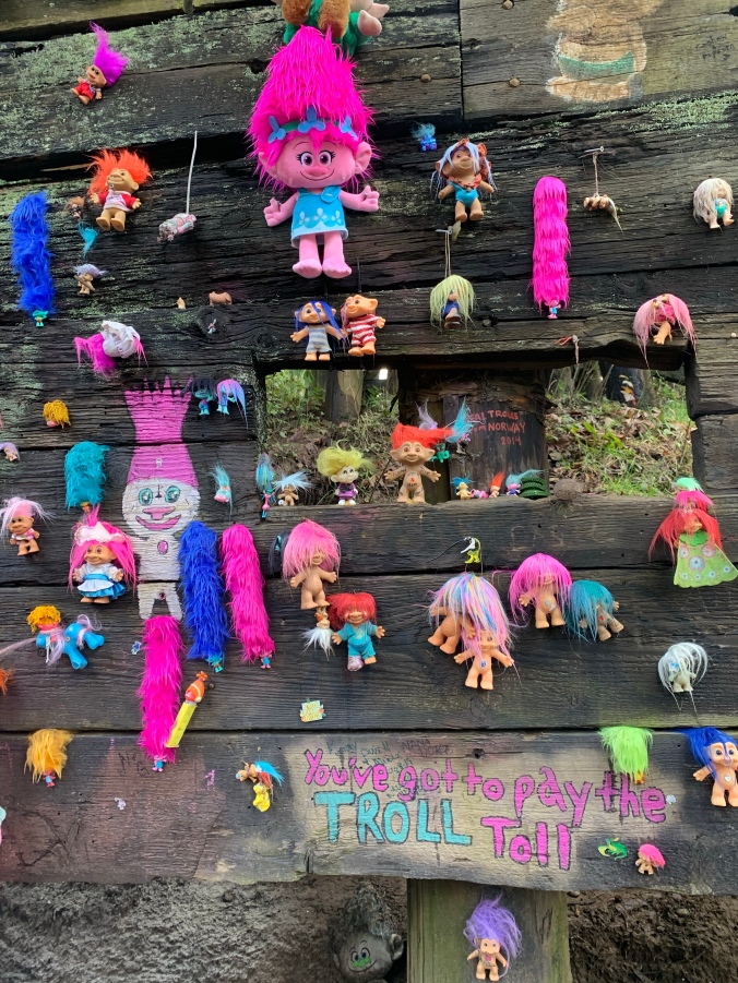 Troll dolls nailed to wooden railroad trestle in Portland Oregon