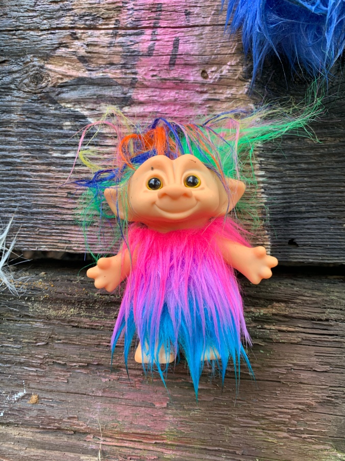 Troll toy with rainbow hair and fur suite